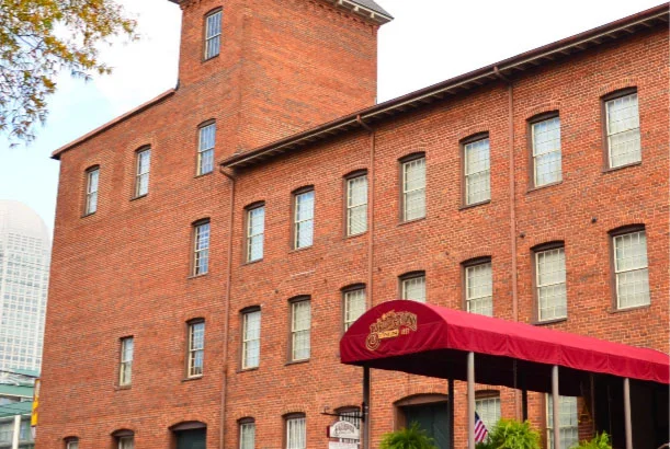 A charming Winston-Salem wedding venue featuring a red brick building with a stylish red awning.