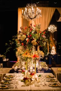 A beautifully decorated wedding table set with flowers and a chandelier at a stunning Winston-Salem wedding venue.
