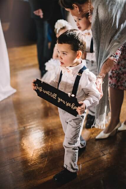 At a winston-salem wedding venue, a little boy holds a sign.