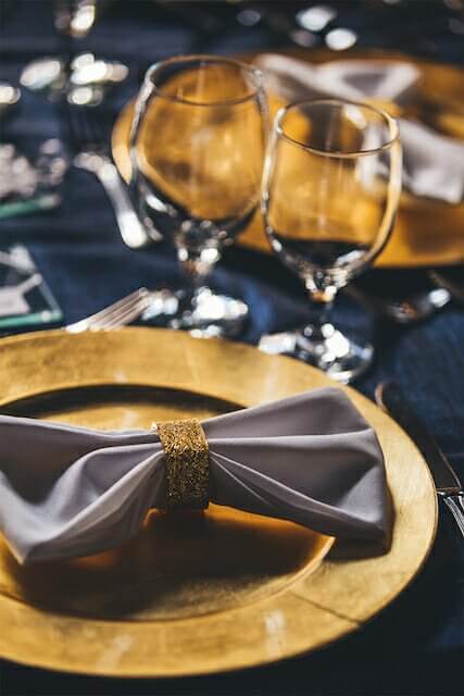 A gold table setting with a napkin and silverware at a Winston-Salem wedding venue.