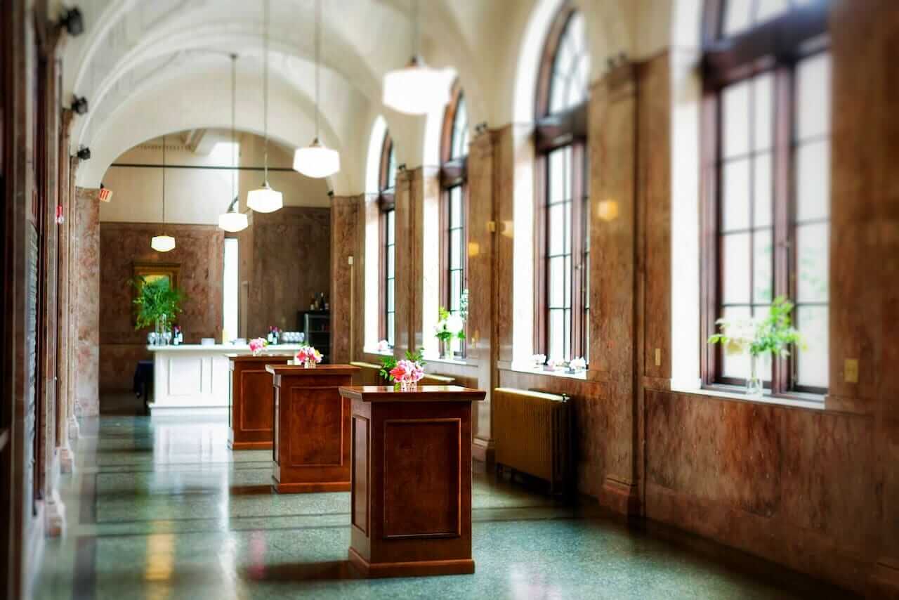Located in Winston-Salem, this spacious wedding venue features a long hallway adorned with numerous windows, allowing ample natural light to drench the space.
