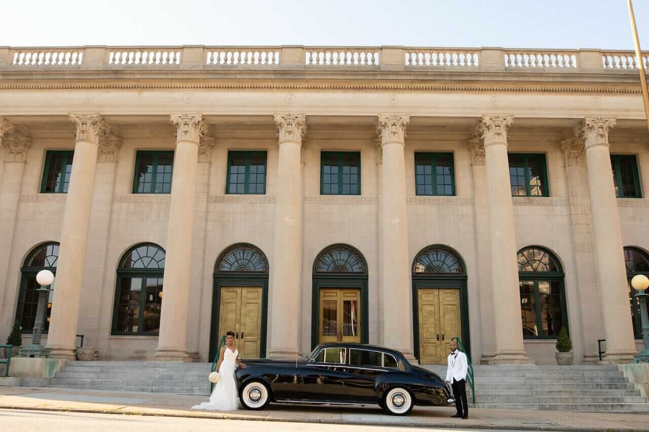 A bride and groom standing in front of an ornate Winston-Salem wedding venue.