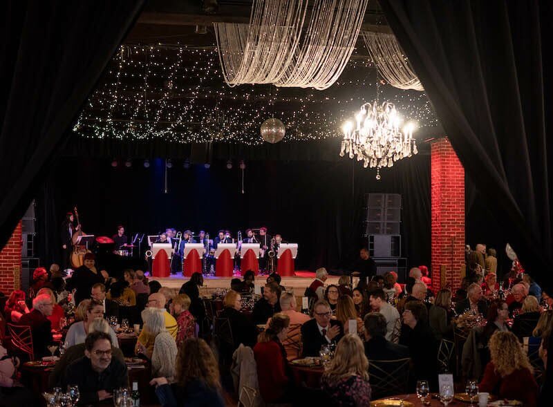 A crowded gathering at tables in an auditorium, serving as a winston-salem wedding venue.
