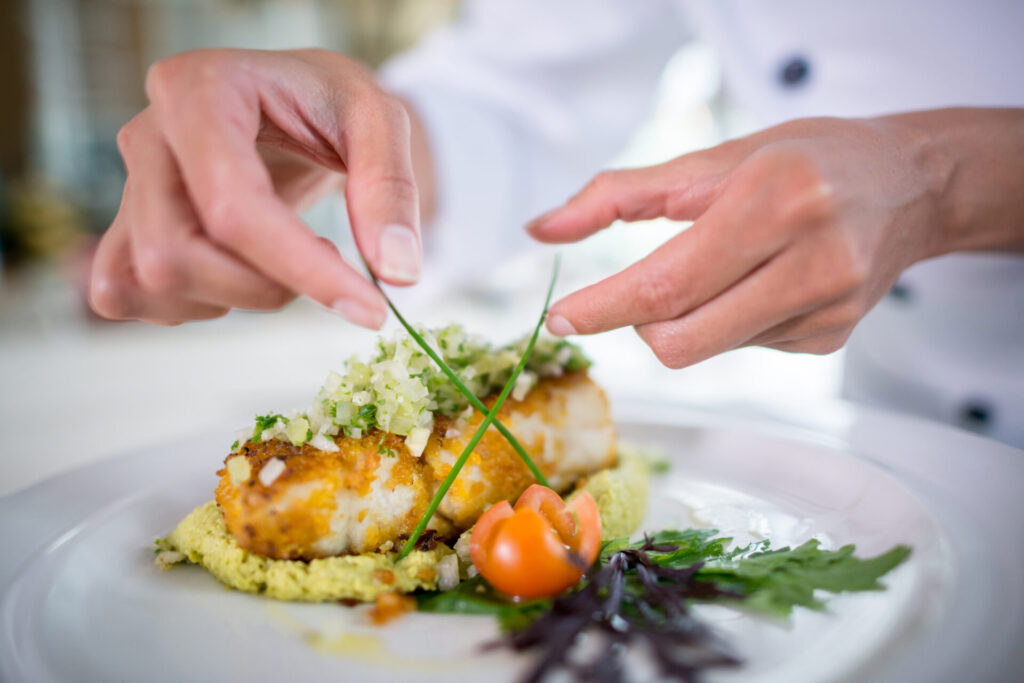 Close up on hand of a Chef decorating a beautiful plate