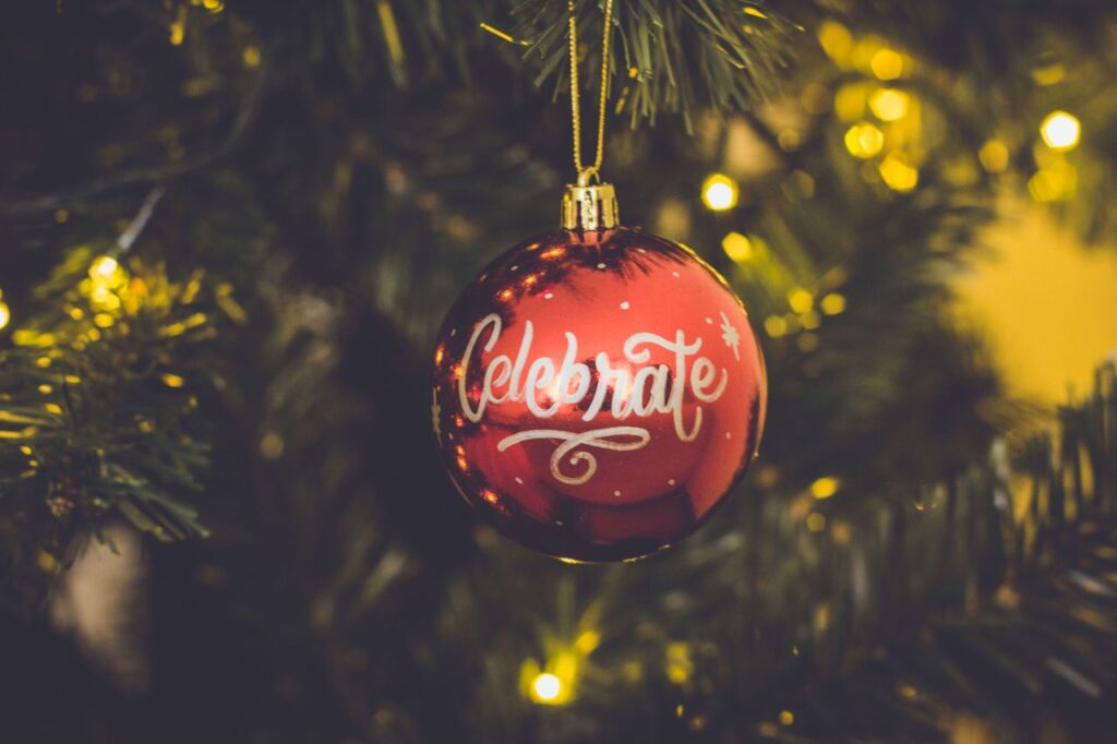 A red holiday ornament that says Celebrate