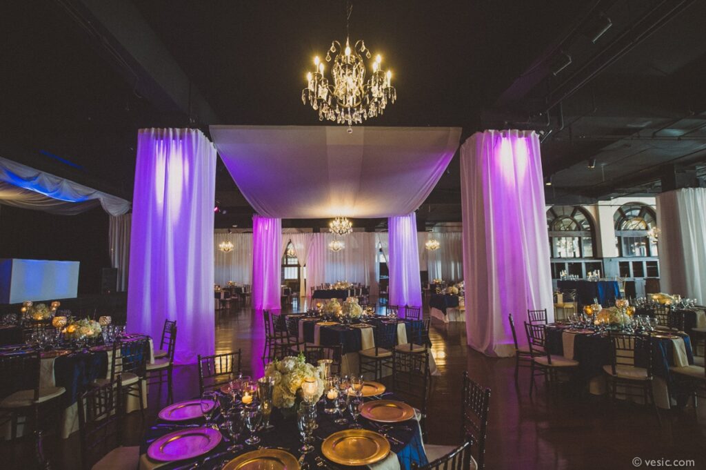 Beautiful purple lighting highlighting white draped columns in the ballroom of Winston-Salem Millennium Center.