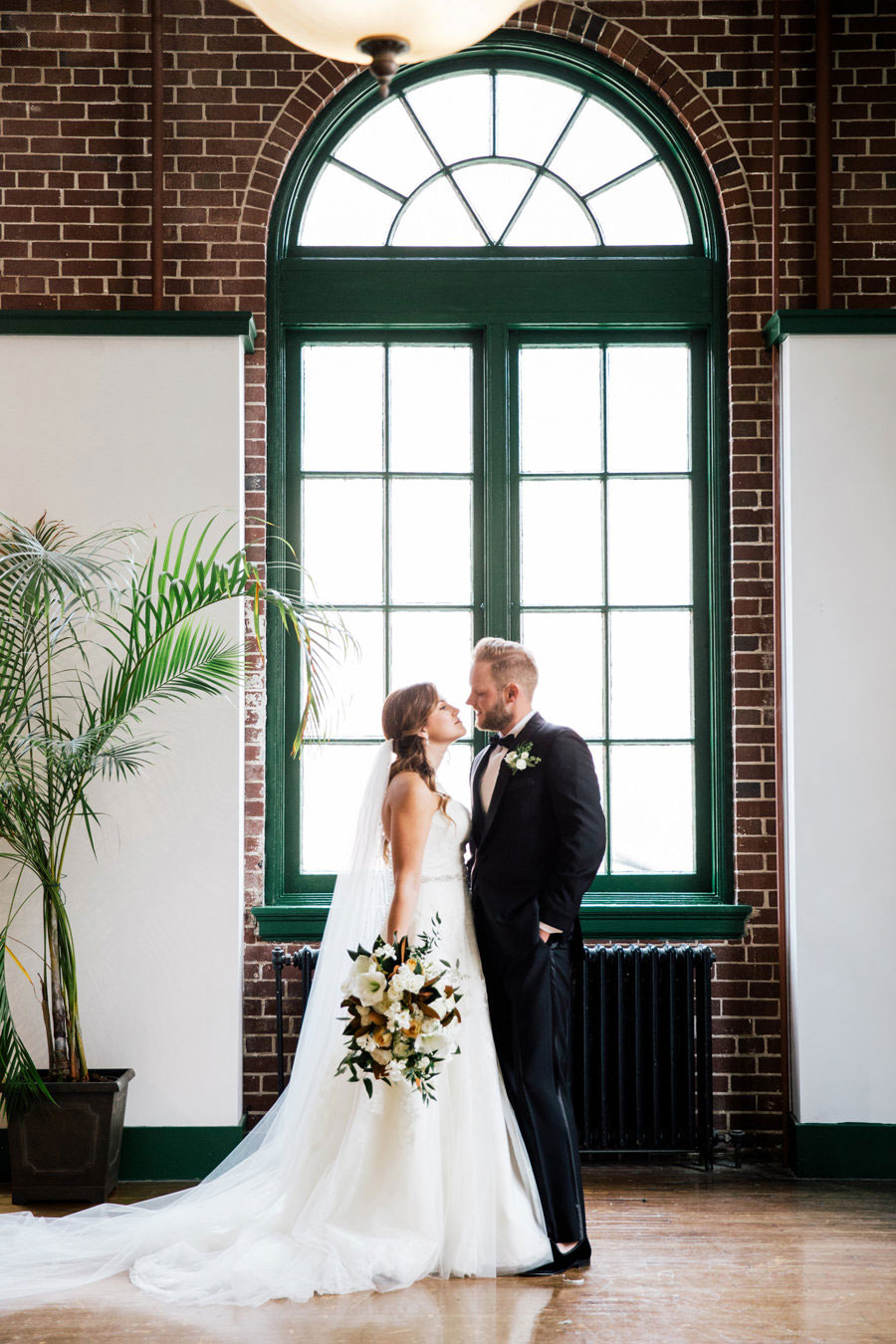 bride-and-groom-by-millennium-event-center-window