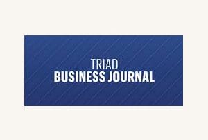 Trad business journal logo on a blue event venue.